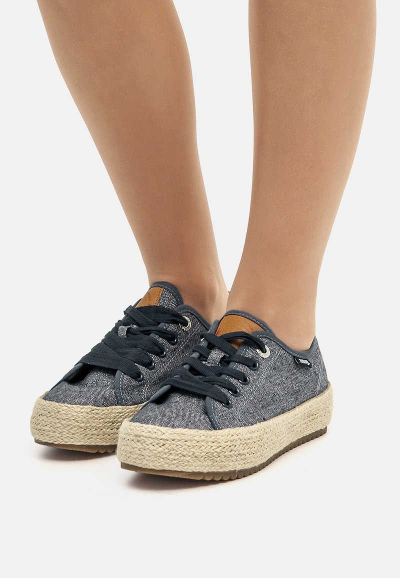 Zapatillas de lona azules con suela de yute trenzada. Punta redondeada, cordones oscuros en contraste y detalle del logo en el lateral. Tejido texturizado.