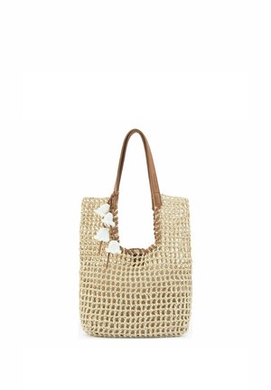 Sac fourre-tout tissé beige avec poignées en cuir marron et pampilles blanches suspendues près de l'ouverture supérieure.