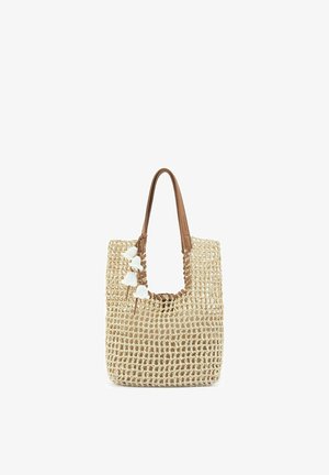 Beige geweven shopper met bruine leren handvatten en witte kwastjes die dichtbij de bovenste opening hangen.