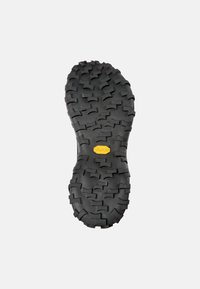 Svart gummiskosula med djup, robust mönster. Har en framträdande gul Vibram-logotyp i mitten. Hållbar och utformad för grepp.