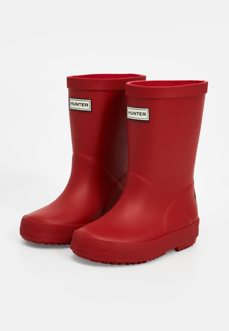 Par de botas de goma rojas de media caña con suelas texturizadas y el logo "Hunter" en la parte frontal, mostradas sobre un fondo blanco.