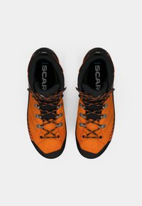Scarpe da esterno arancioni con accenti neri, upper testurizzato e lacci grigi. Presentano una punta in gomma e un tallone rinforzato per una maggiore durata.