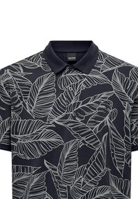 Navy polo shirt featuring a white leaf pattern, textured fabric, with a traditional collar and three-button placket for closure.