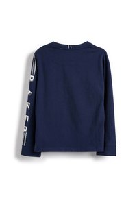 Marineblaue langärmlige Baumwollbluse. Mit Rundhalsausschnitt und grafischem Text entlang des linken Ärmels. Glatte Textur und lockere Passform.