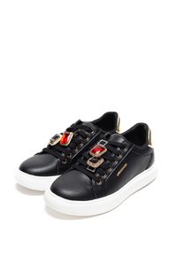 Black leather sneakers with white soles, featuring decorative gems in red and blue on the laces and gold accents on the heel.