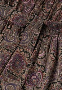 Fabric with intricate paisley pattern in purple, black, red, and beige tones, featuring a tied belt and gathered stitching.