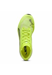 Zapatilla deportiva amarilla brillante con parte superior de malla texturizada, acentos en negro y texto prominente "RUN" en la plantilla. Cuenta con cordones tradicionales.