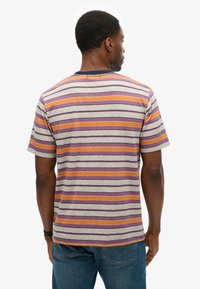 Herrementær er der med kortærmet T-shirt i lys grå med vandrette striber i orange, lilla og marineblå. Lavet af bomuldsmateriale med en rund halsudskæring.