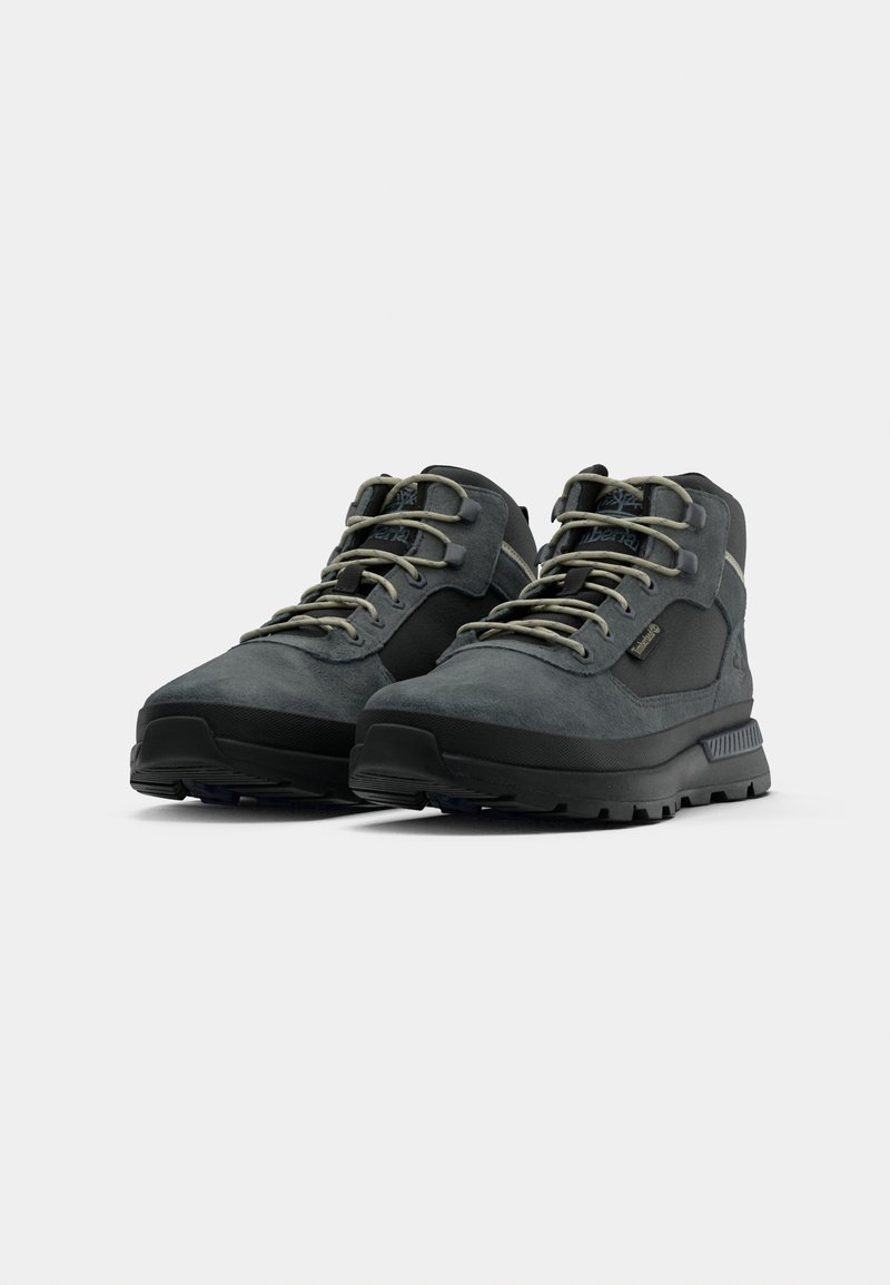 Pair of dark gray suede and mesh hiking boots with beige laces and black rugged soles, positioned side by side on a white background.