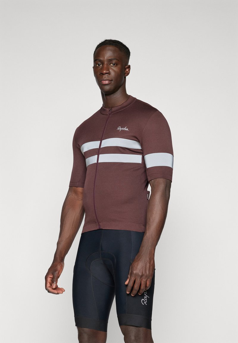 Krátký rukáv cyklistický dres v tmavě vínové barvě se šedými pruhy, vyrobený z elastického materiálu; má přední zip a slim fit střih.