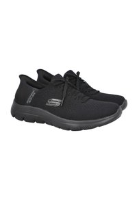 Zapatillas deportivas negras con una parte superior de malla transpirable, cierre con cordones, suela acolchada y una superficie texturizada. Presentan un acento de logo en el costado.