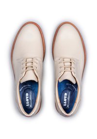 Scarpe eleganti in pelle beige con punta rotonda, suola marrone e soletta blu, dotate di lacci e una finitura liscia e opaca.
