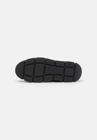 Semelle de chaussure en caoutchouc noir avec un motif de semelle, comportant des sections rectangulaires et ovales pour plus d'adhérence. Marque "Cablor" embossée.