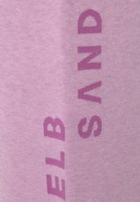 Lichtpaarse stof met vetgedrukte, contrasterende tekst in donkerpaars. De textuur is zacht en glad met een casual ontwerp.