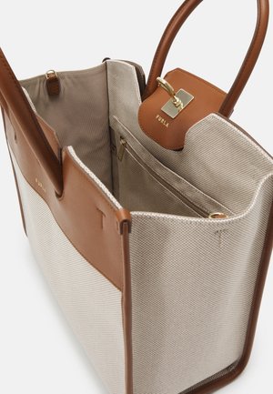 Beige og tan Furla shoppertaske med læderhåndtag, forlommer og gyldent spænde, der viser rummeligt stofforet indre og inderlomme med lynlås.