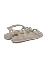 Beige suède sandalen met kruisriemen versierd met heldere rhinestones. Platte zool met een subtiele glinsteraccent op de rand.