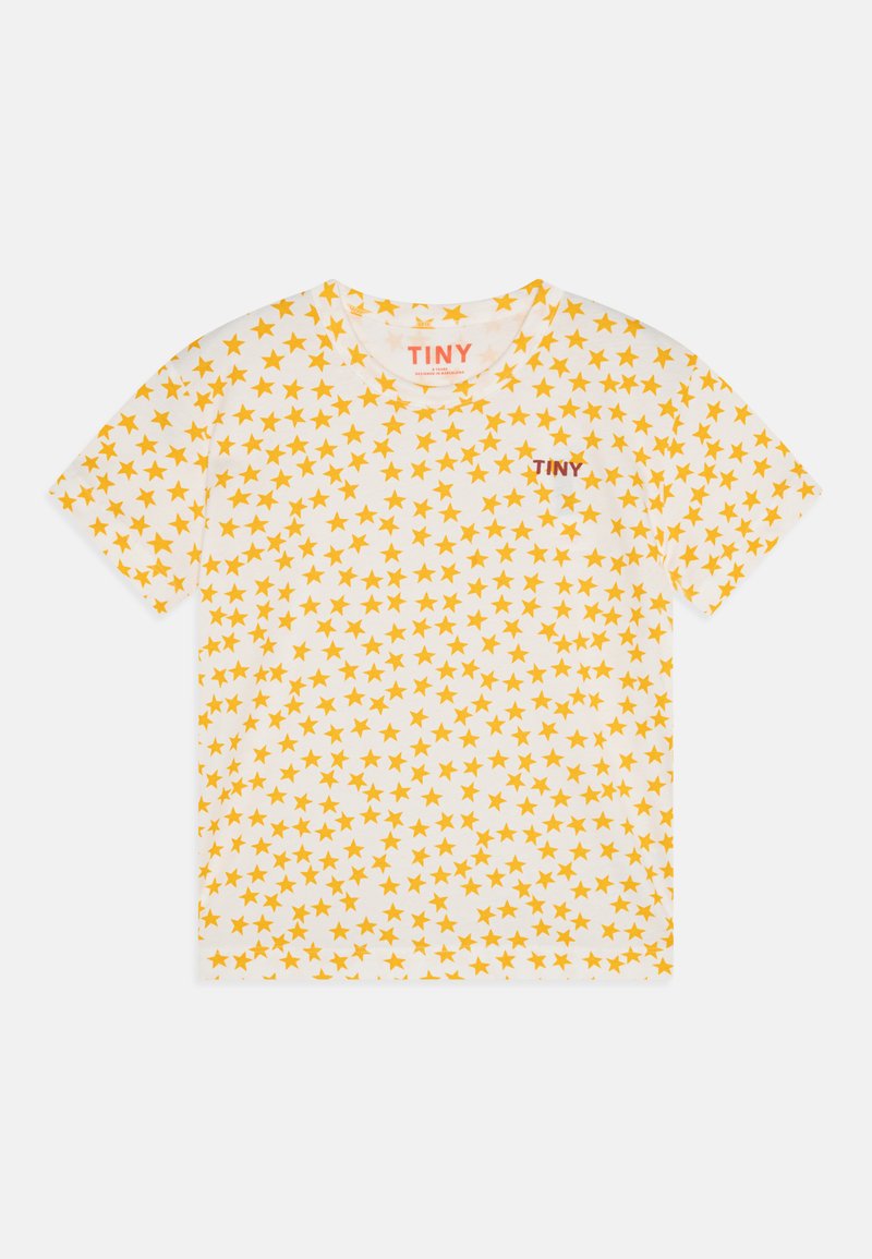 Valge T-särk, millel on kollaste tähtede muster, lühikesed varrukad, ümmargune kaelus ja väike punane "TINY" logo ees.