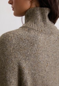 Sweter dzianinowy z wysokim, prążkowanym kołnierzem. Wykonany z teksturowanej, wielokolorowej przędzy w ziemistych odcieniach brązu, szarości i kremu.