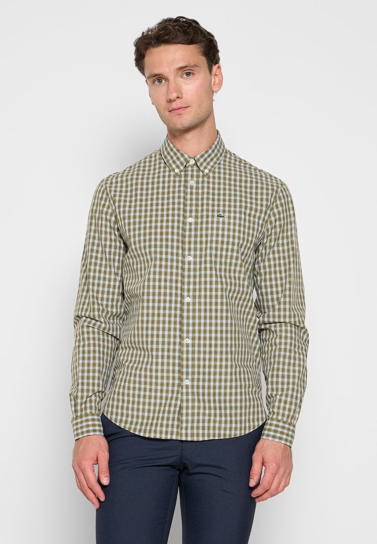 Hemd mit Knöpfen, das ein grün-weißes Karomuster aufweist. Hergestellt aus Baumwolle mit einem klassischen Kragen und einem kleinen Logo auf der Brust.