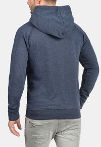 Dunkelblauer Kapuzenpullover aus strukturiertem Stoff, mit einer geräumigen Kapuze sowie gerippten Bündchen und Saum. Die Rückansicht zeigt ein schlichtes, sauberes Design.