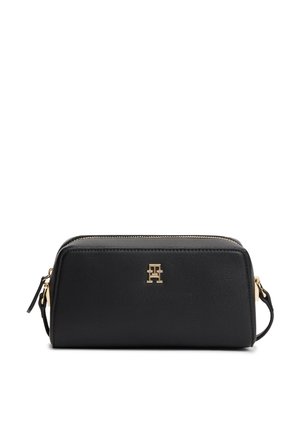 Czarna prostokątna skórzana torebka z złotym zamkiem błyskawicznym i logo TH, z paskiem na nadgarstek z boku.