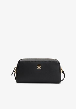 Czarna prostokątna skórzana torebka z złotym zamkiem błyskawicznym i logo TH, z paskiem na nadgarstek z boku.
