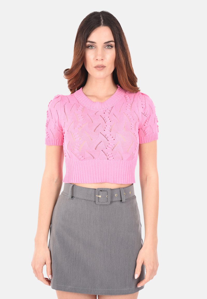 Cropped top rosa in maglia con maniche corte, caratterizzato da un motivo intrecciato e polsini a coste, abbinato a una gonna grigia aderente con una cintura.