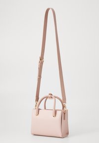 Small pink leather handbag with dual top handles, adjustable shoulder strap, textured surface, and gold-tone hardware accents.