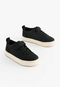 Zwarte sneakers met een glad bovenwerk van synthetisch materiaal, veters en klittenbandsluiting, een crèmekleurige rubberen zool en een rond toel ontwerp.
