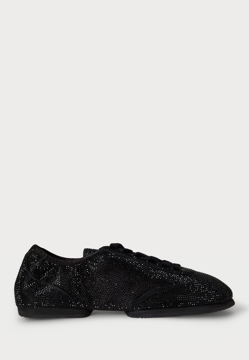 Black flat shoes covered in sparkly material, featuring a rounded toe, lace-up design, and a soft fabric lining. Smooth outsole and minimal tread.