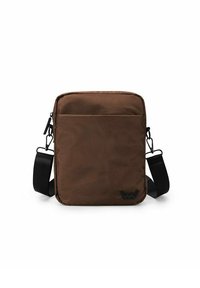 Hnědá crossbody taška vyrobená z látky, s kapsou na zip vpředu, nastavitelným popruhem a logem na dolním pravém rohu.