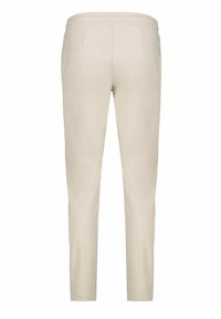 Béžové sportovní kalhoty s hladkou texturou, zúženými nohavicemi, elastickým pasem a dvěma zadními kapsami. Minimalistický design bez vzorů.