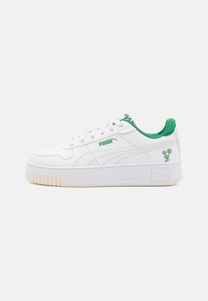 Zapatilla blanca con parte superior de cuero texturizado, acentos verdes en el collar y el logo, y una suela de goma gruesa con ranuras. Detalle floral en el lateral.