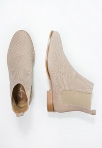 Beżowe botki za kostkę z teksturowaną cholewką, elastycznymi panelami bocznymi i drewnianym obcasem, z gładką podszewką i okrągłym noskiem.