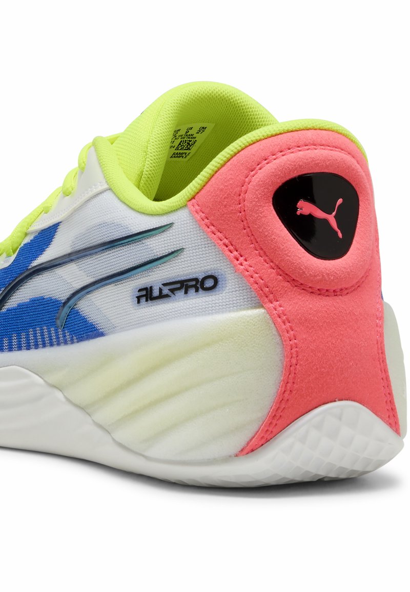 Sneakers Puma z białą siateczkową cholewką, niebieskimi i różowymi akcentami, zielonym wykończeniem i teksturowanym różowym piętą. Posiadają czarne logo i elegancki design.