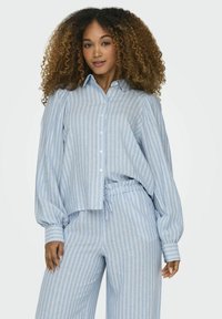 Cămașă cu dungi albastre deschise, cu butoane și mâneci bufante, asortată cu pantaloni cu dungi la talie înaltă. Țesătură moale, croială lejera.