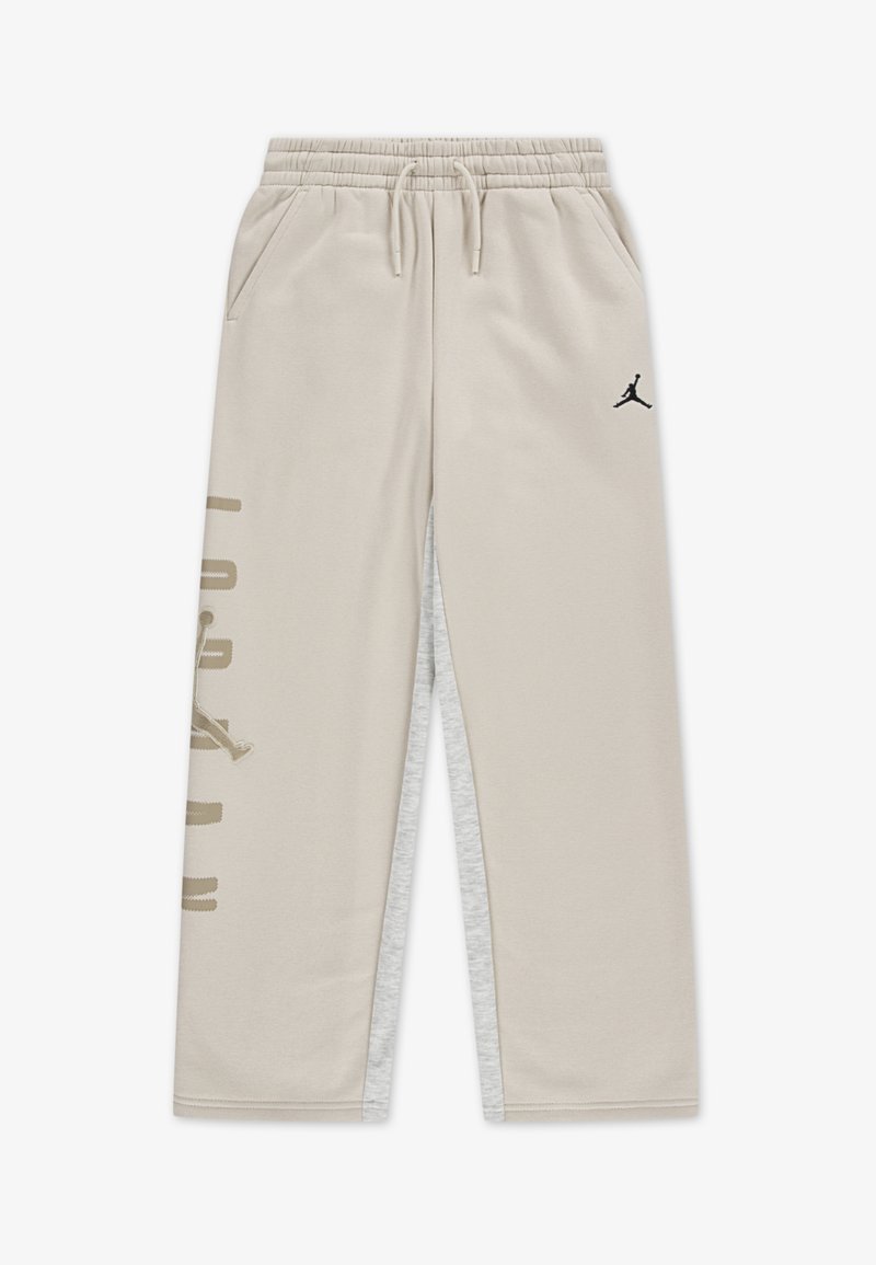 Beige joggebukser med elastisk midjebånd, to sidelommer og en sort Jordan-logo. Har sidesømmer i lysegrå.