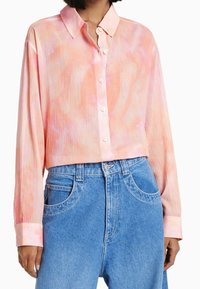 Geknipte langelijst-shirt van lichtgewicht stof, met een roze en oranje tie-dye patroon, een puntige kraag en knoopsluiting.