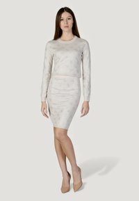 Ensemble coordonné gris clair composé d'un haut à manches longues à motifs et d'une jupe ajustée, tous deux rehaussés d'accents métalliques subtils.