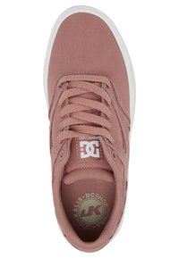 Vaaleanpunainen kangastennari, jossa valkoinen kumipohja, pyöreä kärki ja litteät nauhat. Kielen osassa on logotarra ja pohjallinen on kuvioitu.