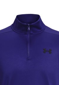 Lila Quarter-Zip-Pullover aus dehnbarem Gewebe. Mit einem schwarzen Under Armour-Logo auf der Brust und einer glatten Textur.