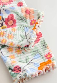 Värikäs resorikangas, jossa on kukkakuviot vaaleanpunaisena, oranssina ja sinisenä sekä pastellinsävyiset röyhelöreunukset.