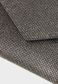 Clutch nera con texture e finitura metallica, caratterizzata da una superficie di piccole borchie lucide e una chiusura a patta triangolare.