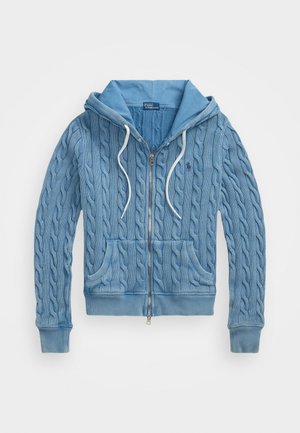 Svetlo modrá zásuvná mikina s káblovým pletením, dvoma prednými vreckami, sťahovacími šnúrkami a kontrastným podšívkou kapucne. Mäkče textúra.