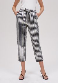 Pantalons à rayures taille haute avec ceinture à nouer, en tissu léger bleu marine et blanc. Comprend des poches latérales et une longueur raccourcie.