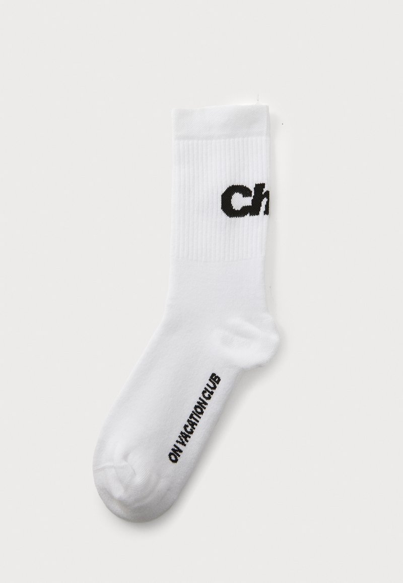 Valge puuvillane lühike sokk, mille ülaserval on must trükitud tekst "Ch" ja talla ääres "ONV ACTION CLUB", ribatekstuuriga.