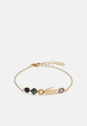 Bracciale in oro con charm a forma di coccodrillo e cinque pietre multicolori: rotonda viola, diamante verde, rotonda gialla e ovale rosa.