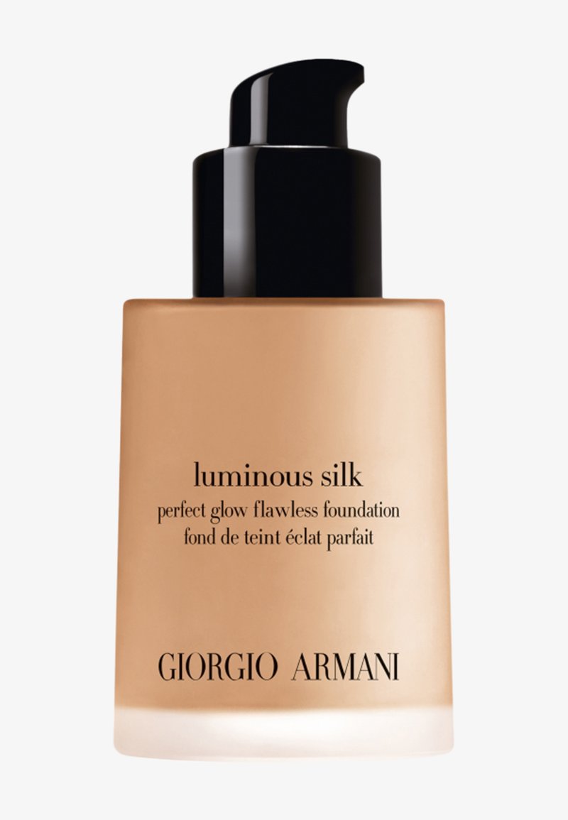 Fond de teint Luminous Silk de Giorgio Armani dans un flacon en verre transparent. Il présente un haut de pompe noir et une étiquette élégante avec un texte doré.