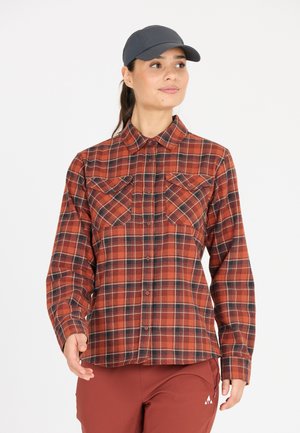Chemise à carreaux rouge et noir avec un devant boutonné, un col et deux poches poitrine. Fabriquée dans un tissu à texture douce. Manches longues, coupe décontractée.