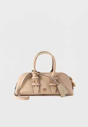 Τσάντα ώμου από μπεζ σουέντ με δύο λαβές, μακρύ λουράκι, χρυσές αγκράφες και μια μικρή κρεμαστή ταμπέλα με το ανάγλυφο όνομα της μάρκας.